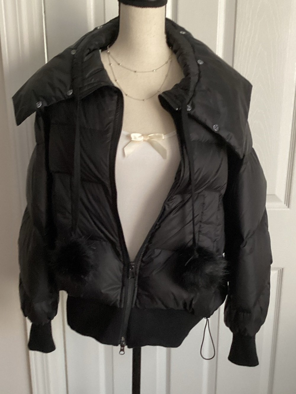 black puffer jacket with pom pom details